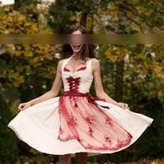 SP Escort Agency Munich, Jessica in a beige-red Dirndl with highheels. Shes swinging her skirt whilst smiling, in a garden.